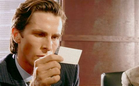 patrick bateman looking at card.